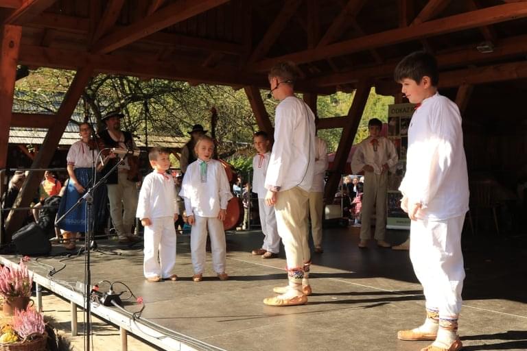 Na scenie śpiewają dzieci w tradycyjnych strojach okolic Łomnej Dolnej.